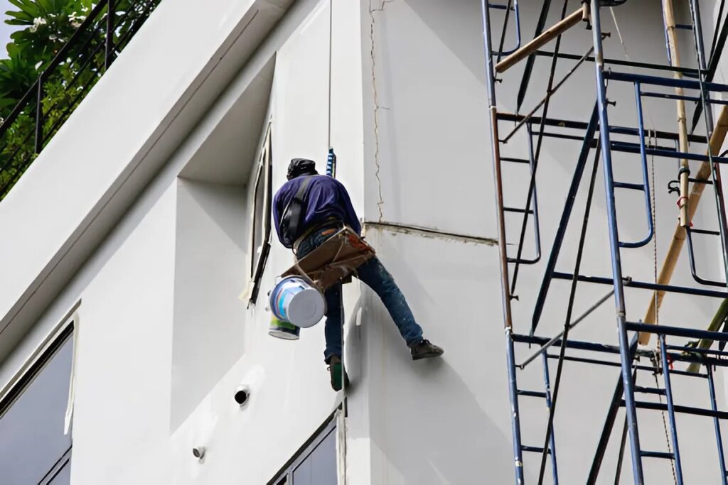 Professional exterior painter in Manitou, CO applying paint to a business property