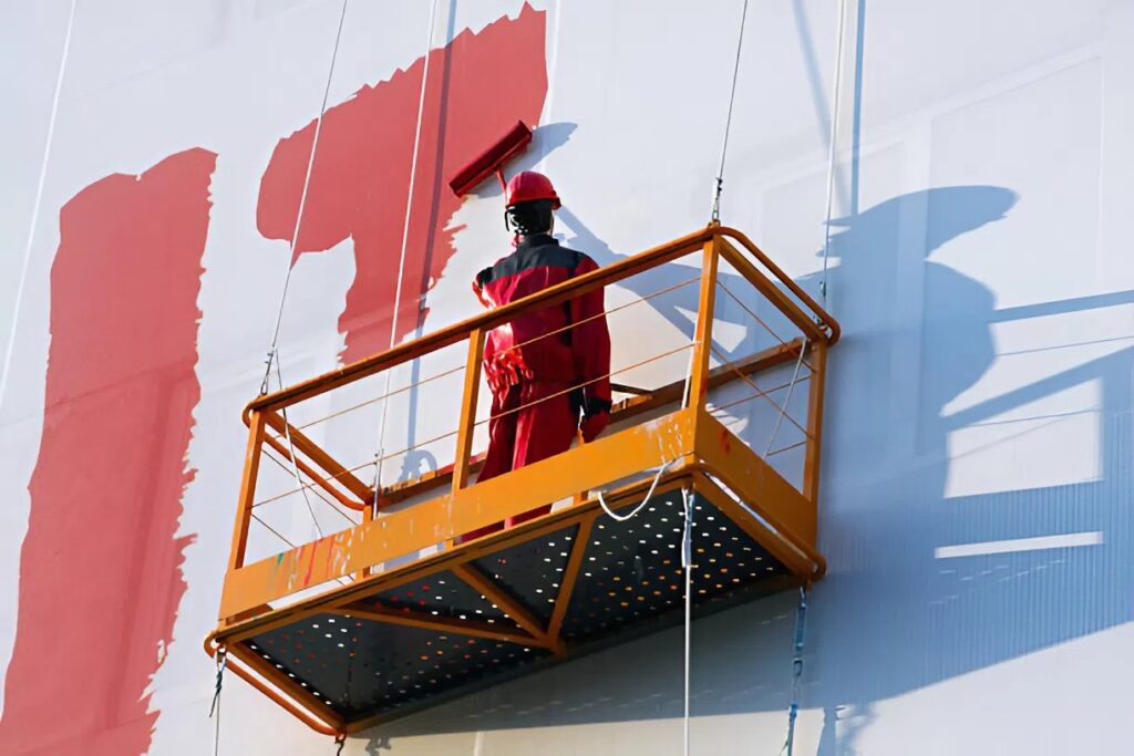 Commercial painter applying exterior paint to a building facade in Old Colorado City, CO